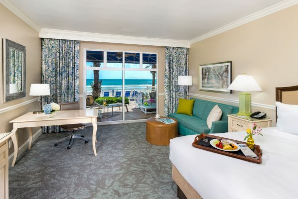 Cabana room with an ocean view, bed, desk, couch, and served breakfast.