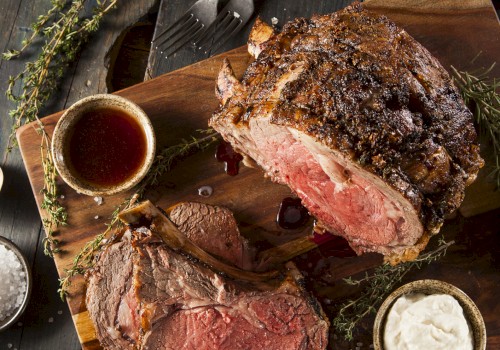 A perfectly roasted beef loin, sliced to reveal a juicy pink center, served with sauces and fresh herbs on a rustic board.