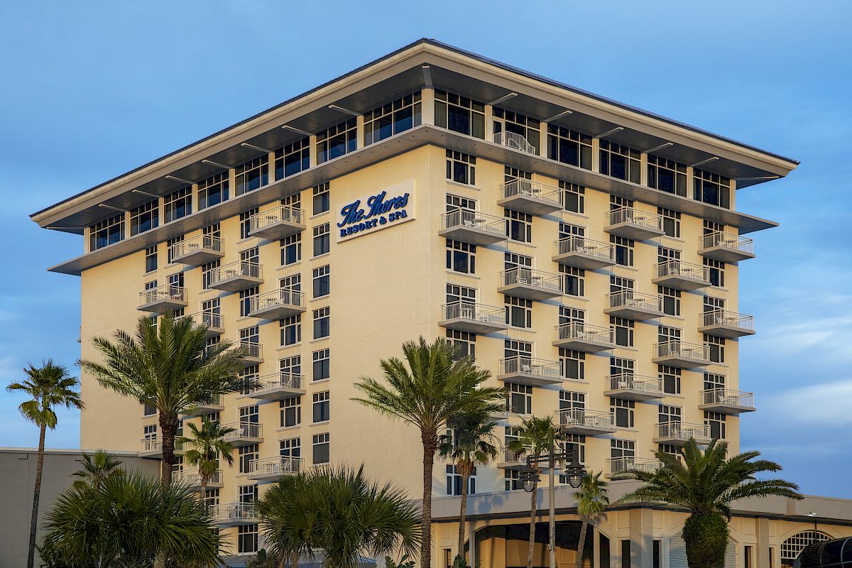 The image depicts a multi-story building with a sign reading 