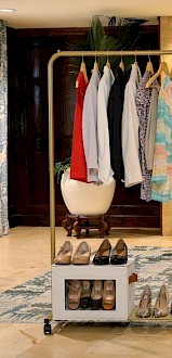 A clothing display with dresses, shoes, and a banner encouraging women to leave business behind and make an impact through empowerment.