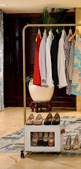 A clothing display with dresses, shoes, and a banner encouraging women to leave business behind and make an impact through empowerment.