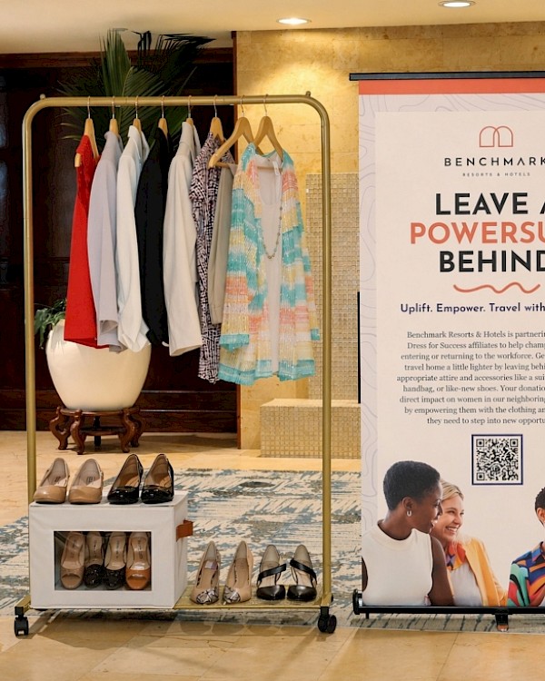 A clothing and shoe display next to a sign encouraging women to leave a power suit behind and travel with purpose.