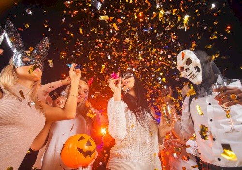 People celebrating Halloween at a party with costumes, masks, a pumpkin basket, and falling golden confetti.
