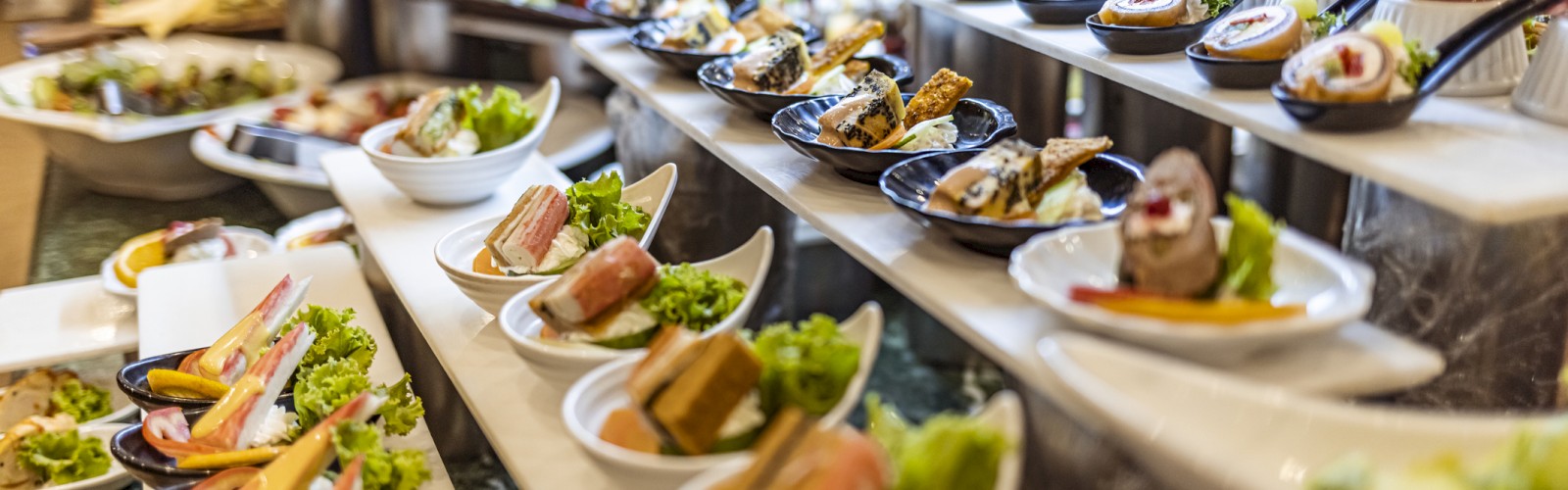 Buffet spread with a variety of neatly plated appetizers.