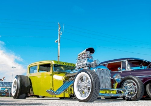 The image shows two vintage hot rods parked under a clear blue sky, one green and one dark red, with visible chrome detailing and large engines.