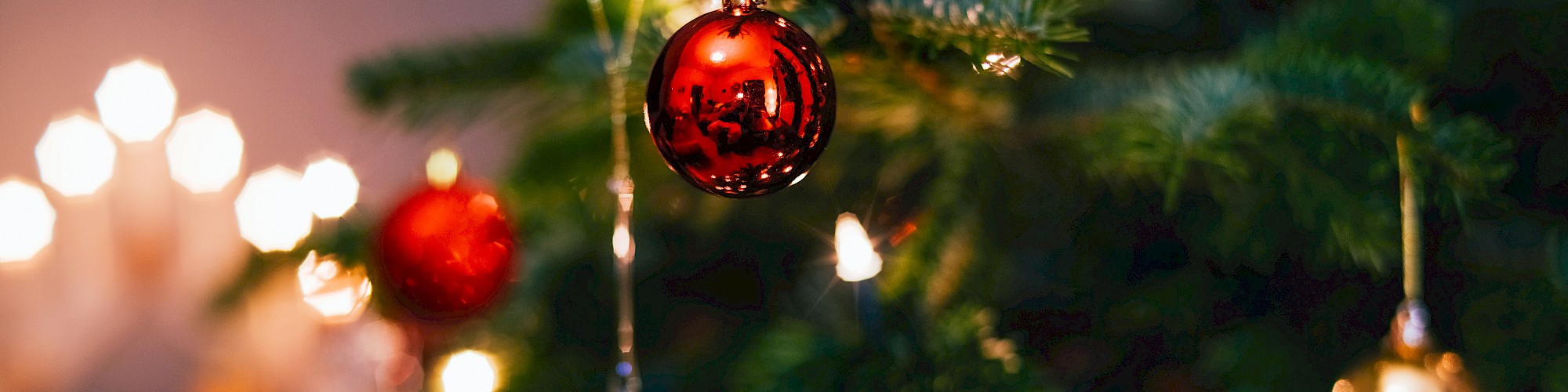 A decorated Christmas tree with red and gold ornaments and glowing lights creates a festive ambiance.